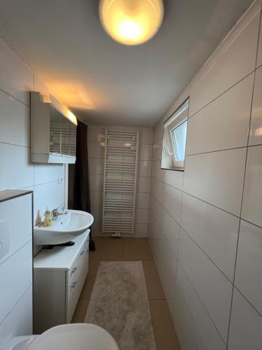 a white bathroom with a sink and a toilet at CALM HOME im Erdgeschoss mit eigenem Eingang in Bad Oeynhausen