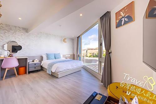 una camera da letto con un letto, una scrivania e una finestra di 墾丁卿卿文旅 a Città Vecchia di Hengchun