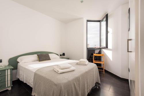 een slaapkamer met een bed met twee handdoeken erop bij Apartamento Tramontana 28B in Fornells