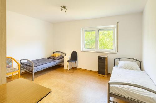 a room with two beds and a window at GMA Apartment P8 in Lahr