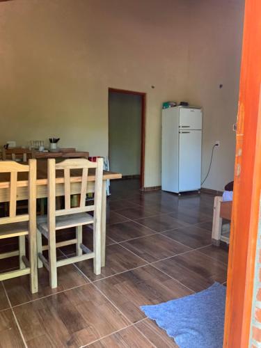 een keuken en eetkamer met een tafel en een koelkast bij Cabañas la flor 