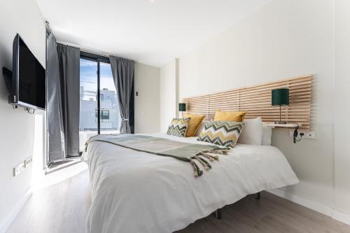 een witte slaapkamer met een groot bed en een raam bij Casa Miramar Oak 47 in Fuengirola