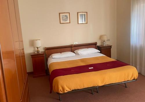 a bedroom with a bed with two night stands and two lamps at Albergo Casa Sperti in Spert