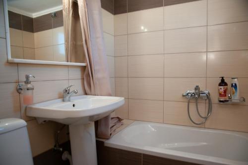 a bathroom with a sink and a bath tub at GLIPTIS Apartments in Chios