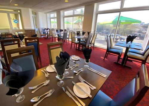 een eetkamer met een tafel met borden en bestek bij Tor Park Hotel in Torquay