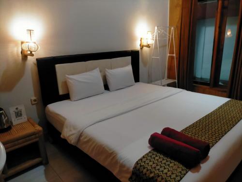 een slaapkamer met een groot wit bed met twee kussens bij Tania Homestay in Bumbang