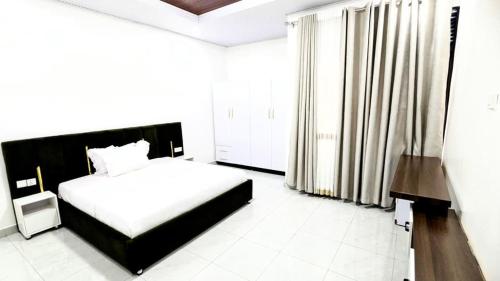 a bedroom with a bed and a large window at ishema hotel in Kigali