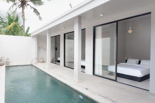 a bedroom with a swimming pool and a bedroom with a bed at Villa IKIN in Lovina