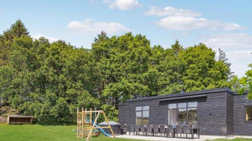 a small black house with a playground at Villavilla 581 - Gjerrild, Østjylland in Grenå