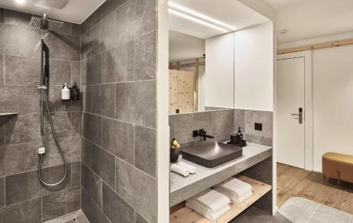 a bathroom with a sink and a shower at The Suites in St. Moritz