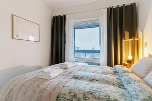 a bedroom with a large bed with towels on it at Luxury Apartment By Lapland Host in Rovaniemi
