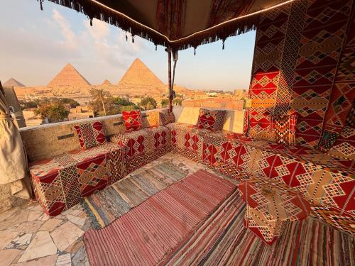 Ein Zimmer mit einer Couch und den Pyramiden im Hintergrund in der Unterkunft New Arena pyramids VIEW in Giza