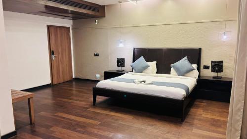 THE SLATE HOTEL NUMGAMBAKKAM Near US EMBASSY & APPOLLO HOSPITAL في تشيناي: غرفة نوم بسرير كبير مع وسائد زرقاء