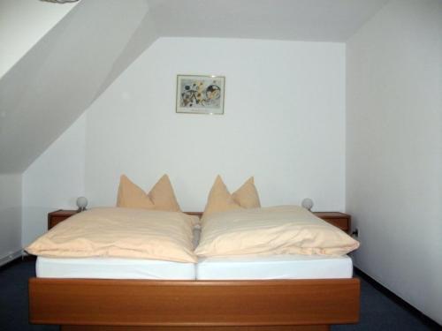 Bett mit Kissen darauf in einem Zimmer in der Unterkunft Hotel-Gasthaus Burmester in Heidenau