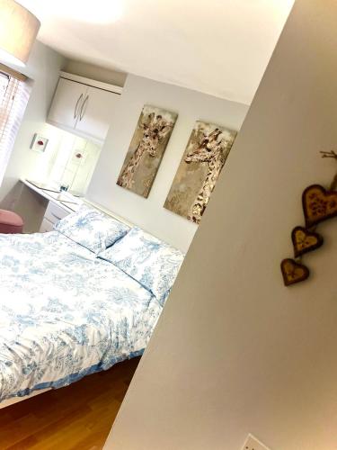 a bedroom with a bed and two pictures on the wall at Village Cottage Marple in Marple