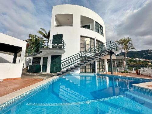a house with a swimming pool in front of a building at Blue Horizon House in Funchal