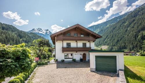 een huis met een garage voor een berg bij Landhaus Tyrol in Mayrhofen