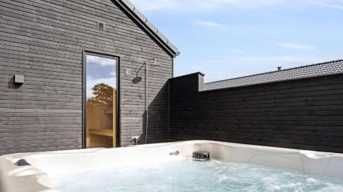 een bad in de hoek van een huis bij Villavilla #910 - Marielyst, Lollandfalstermøn in Stovby