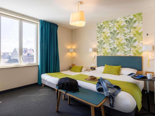 una camera d'albergo con due letti e una finestra di ibis Styles Calais Centre a Calais
