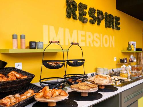 a buffet with various types of bread and pastries at ibis Styles Calais Centre in Calais