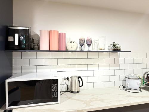 a kitchen with a counter top with a microwave at Modern Studio in Burwood in Sydney