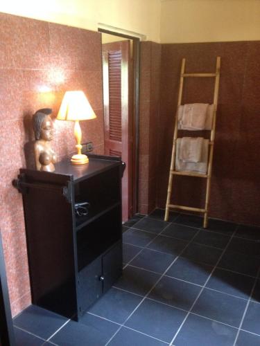 a room with a lamp on a dresser and a ladder at Maison Couleur Passion in Nianing