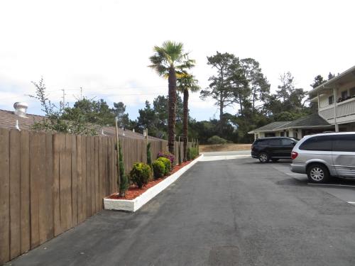 a car parked in a driveway next to a wooden fence at Fisherman's Cove Inn in Monterey