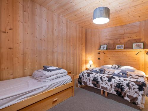 two beds in a room with wooden walls at Chalet confortable pour 10 pers avec sauna à Avoriaz - FR-1-314-193 in Avoriaz