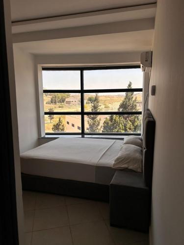 a bed in a room with a large window at Tanger sun studios in Tangier