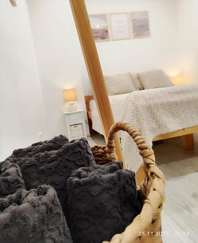 a bedroom with a bed and a basket in the foreground at PortStreet apartamenti in Liepāja