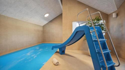 una piscina coperta con uno scivolo blu in una stanza di Villavilla #633 - Mommark, Sydjylland a Sarup