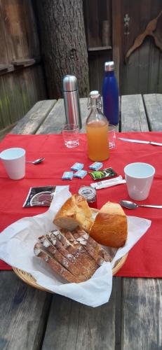 un piatto di carne e pane su un tavolo da picnic di Les cabanes de Labrousse a Saint-Julien-Labrousse