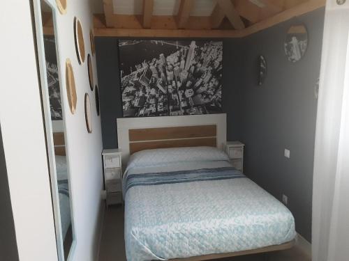 a small bedroom with a bed and a picture on the wall at Entrecuevas - Rural Accommodation in Arredondo