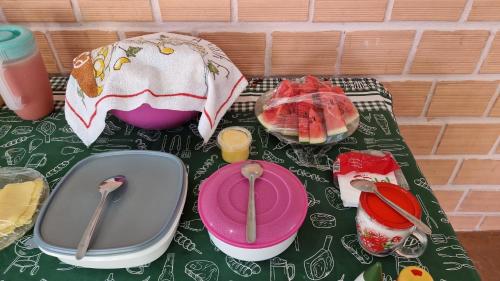 a table with utensils and plates and an umbrella at Pousada Encantos de Paripueira in Paripueira