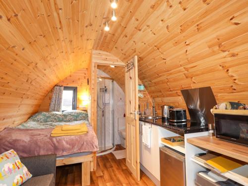 a bedroom with a bed in a tiny house at The Pod at Greenbank in Kilbride