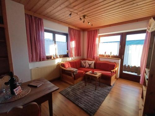 een woonkamer met een rode bank en een tafel bij Ferienwohnung Schösserhof in Reith bei Kitzbühel