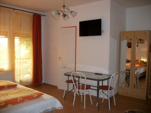 a room with a table and chairs and a bedroom at Éden II. in Miskolctapolca