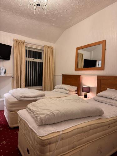 een hotelkamer met twee bedden en een spiegel bij No 34 Vance Road in Blackpool