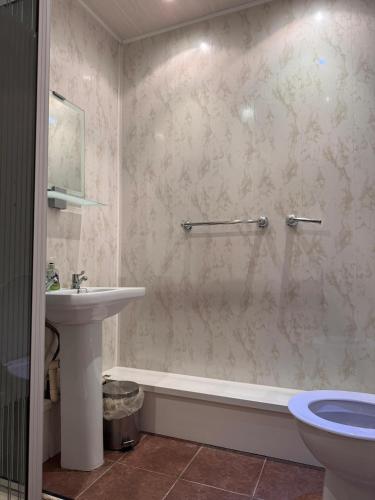 een badkamer met een bad, een wastafel en een toilet bij No 34 Vance Road in Blackpool