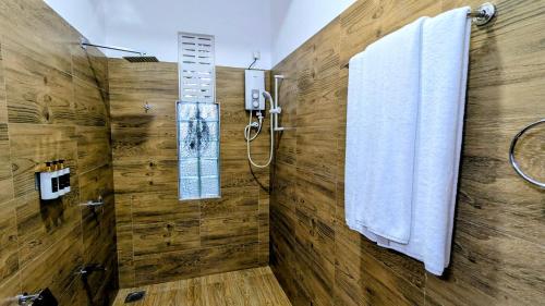 a bathroom with a shower and two towels at Grand Toscana in Udawalawe