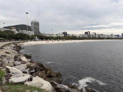 een strand met een stel mensen op het strand bij KITNET ELVIS PRESLEY - Largo do Machado in Rio de Janeiro