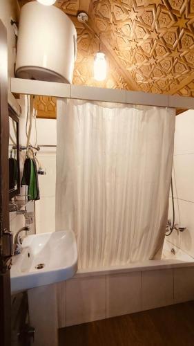 a bathroom with a sink and a shower curtain at Heritage Houseboat - Almost Heaven in Srinagar