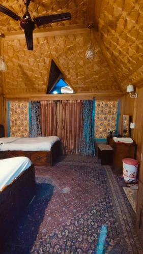 a bedroom with two beds and a ceiling at Heritage Houseboat - Almost Heaven in Srinagar