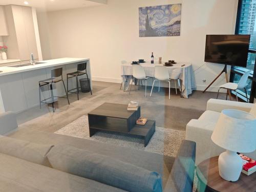 a living room with a couch and a table at Above the Park Sydney Harbour City View Stay in Sydney