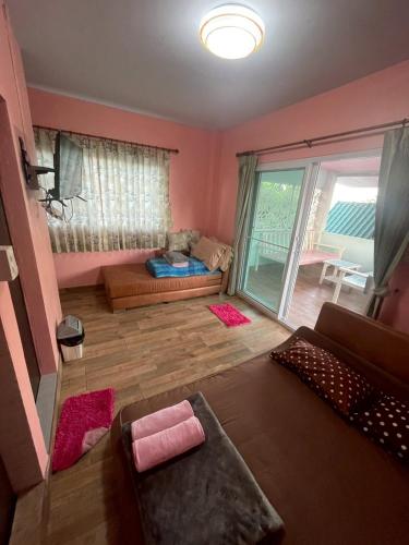 a living room with a couch and a large window at Sea Side Villa in Ban Pak Khlong Cha-am