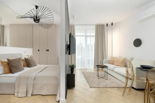 a white bedroom with a bed and a couch at Premium & Elegance Apartments with Pool by Noclegi Renters in Sianozety