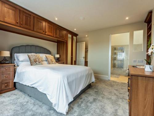 a bedroom with a large bed and a bathroom at 3 Bed in Chale oc-94165 in Chale