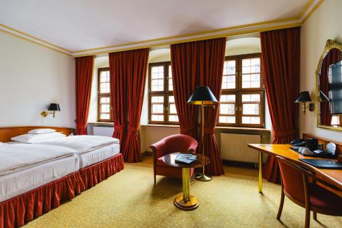 a hotel room with a bed and a desk at Romantik Hotel Bülow Residenz in Dresden