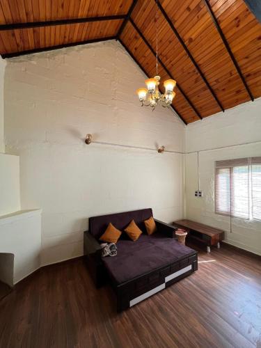 un soggiorno con un divano e un lampadario di Nadi Kinare a Bhimtal