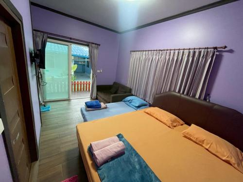 een slaapkamer met een bed en een woonkamer bij Sea Side Villa in Ban Pak Khlong Cha-am